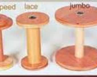 May include: A collection of wooden spools in various sizes, labeled "standard", "high speed", "lace", "jumbo", and "jumbo dbl drv". Each spool has a circular top and base, connected by a central post. The wood tones range from light to medium brown.