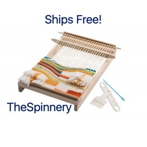May include: A wooden loom with a colorful woven tapestry on it. The loom is set up with white yarn and includes a comb, needle, and shuttle. The text "Ships Free!" and "TheSpinnery" are visible in the image.