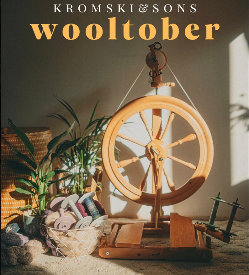 May include: A wooden spinning wheel with a large, round wheel and a smaller, round wheel on the side. The spinning wheel is on a wooden base and is surrounded by yarn and other crafting supplies. The text "Kromski & Sons Wooltober" is visible at the top of the image.