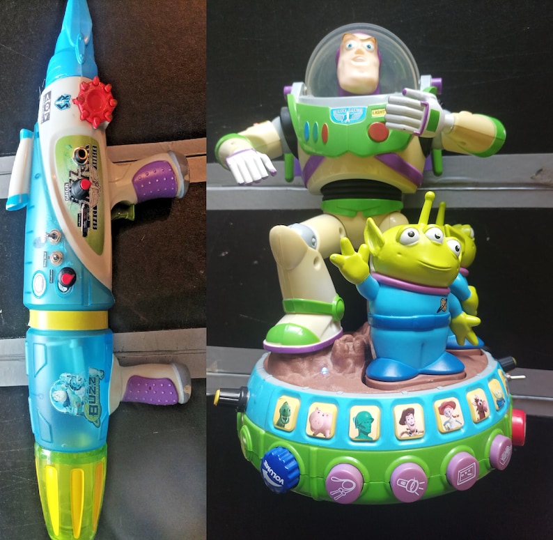 May include: Two Toy Story themed toys. One is a blue and white water gun with a red dial and the word "Buzz" on it. The other is a Buzz Lightyear figure standing on a platform with an alien figure.