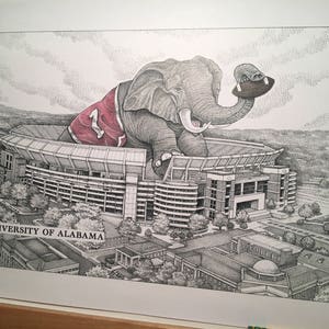 May include: A black and white illustration of an elephant wearing a red and white jersey with the number "1" on it. The elephant is holding a football and is standing in front of a stadium. The text "UNIVERSITY OF ALABAMA" is visible at the bottom of the image.