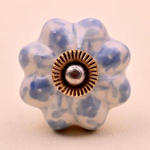Tirador de cerámica hecho a mano con forma de flor, en blanco y azul.