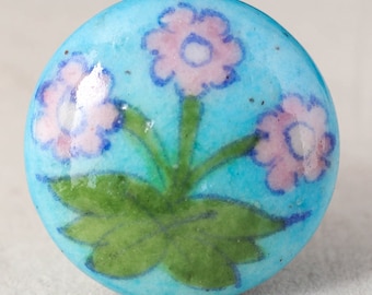 Puxador de gaveta em cerâmica com estampa floral pintada à mão, em tons de turquesa e rosa, estilo vintage.