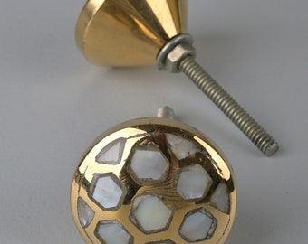 Puxador de gaveta redondo dourado com detalhes em madrepérola e latão.