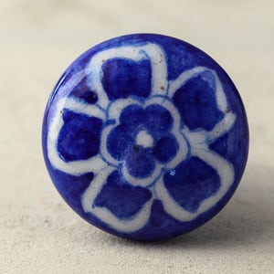 May include: A blue and white ceramic knob with a floral design. The knob is round and has a glossy finish.
