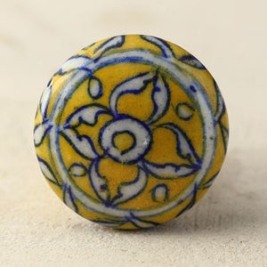 May include: A yellow ceramic knob with a blue and white floral design.