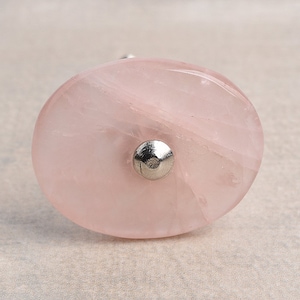 May include: Oval-shaped pink rose quartz cabinet knob with a silver metal base.