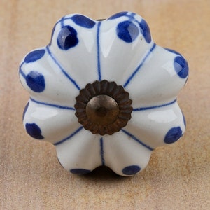 May include: White ceramic cabinet knob with a blue and white floral design and a brass center.