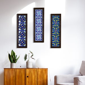 Può includere: Tre pezzi di arte da parete incorniciati con disegni di piastrelle blu e bianche. Le piastrelle presentano motivi floreali e geometrici. Le cornici sono in legno marrone scuro.