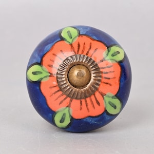 May include: A blue ceramic knob with a bright orange flower design and a gold metal center.