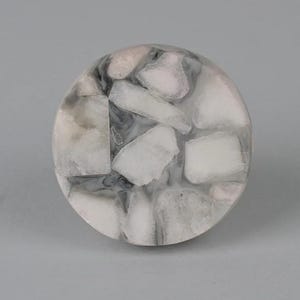 May include: Round, white and gray resin knob with a speckled pattern. The knob has a smooth, polished surface.