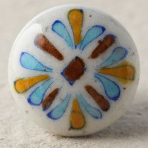 May include: White ceramic knob with a blue, yellow and brown floral design.