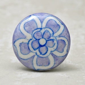 May include: A purple ceramic knob with a white and blue floral design.