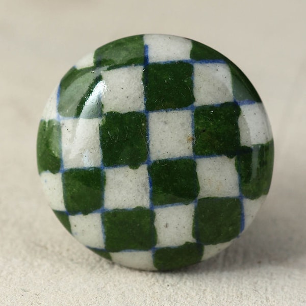 Tirador de cerámica hecho a mano con diseño de tablero de ajedrez verde y blanco.