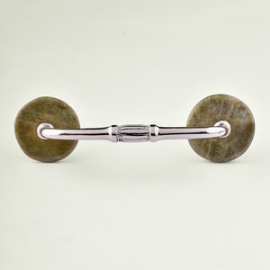 May include: A silver cabinet pull with two round, brown, marbled knobs.