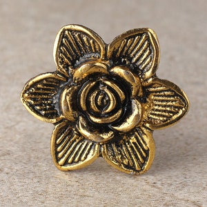 May include: A gold-toned metal flower ring with a detailed rose design.