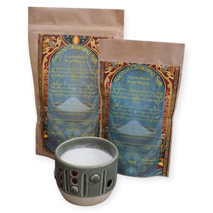 Può includere: Due sacchetti di carta marrone di "Sacred Cleansing Salt" con etichette ornate e una piccola tazza di ceramica grigia piena di sale bianco. I sacchetti hanno disegni blu e oro. La tazza ha un motivo decorativo di cerchi e linee.