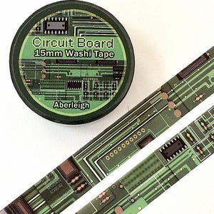 May include: A roll of washi tape and two strips of tape featuring a green circuit board pattern. The label on the roll reads Circuit Board 15mm Washi Tape and Aberleigh. The tape design includes detailed electronic components and circuitry.
