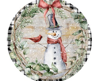 May include: Watercolor illustration of a snowman wearing a top hat, scarf, and bow. A red cardinal sits on a branch. The snowman is surrounded by greenery and a black and white checkered border. The background is a light wood texture.