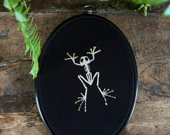 Embroidery hoop, frog skeleton