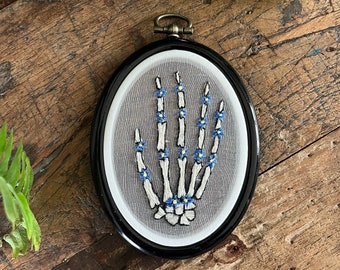 embroidery hoop, skeleton hand with little flowers