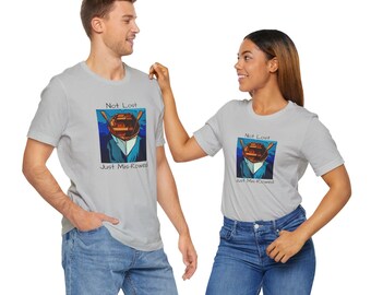 May include: Two people wearing light gray t-shirts with a graphic of a boat and the text "Not Lost Just Mis-Rowed".