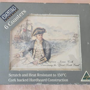 May include: A set of six coasters in a gray box, each with a historical image of Captain James Cook and a ship. The coasters are heat resistant up to 150°C and made with cork-backed hardboard. The box reads "Essentials Homeware".