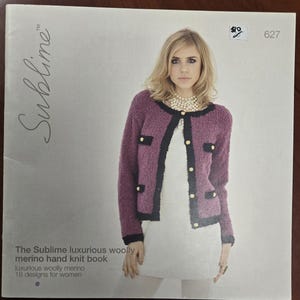 Puede incluir: Portada de libro con una mujer con una chaqueta de lana merino morada con ribetes negros y botones dorados. El texto dice "Sublime" y "The Sublime luxurious woolly merino hand knit book".