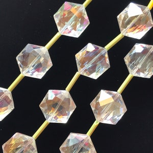 May include: A strand of iridescent clear glass beads with a hexagonal shape. The beads are strung on gold wire.