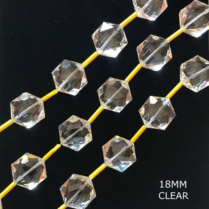 May include: A strand of clear faceted crystal beads, each bead is a hexagon shape. The beads are strung on yellow thread. The text "18MM CLEAR" is visible at the bottom of the image.