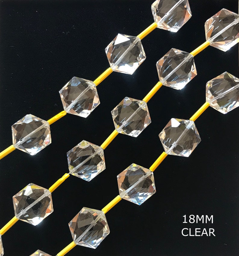 May include: A strand of clear faceted crystal beads, each bead is a hexagon shape. The beads are strung on yellow thread. The text "18MM CLEAR" is visible at the bottom of the image.