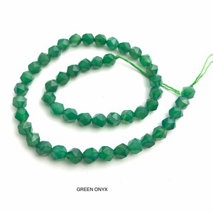 May include: A strand of faceted green onyx beads. The beads are a deep emerald green color and have a geometric shape. The string holding the beads is a light green color. The text "GREEN ONYX" is at the bottom of the image.