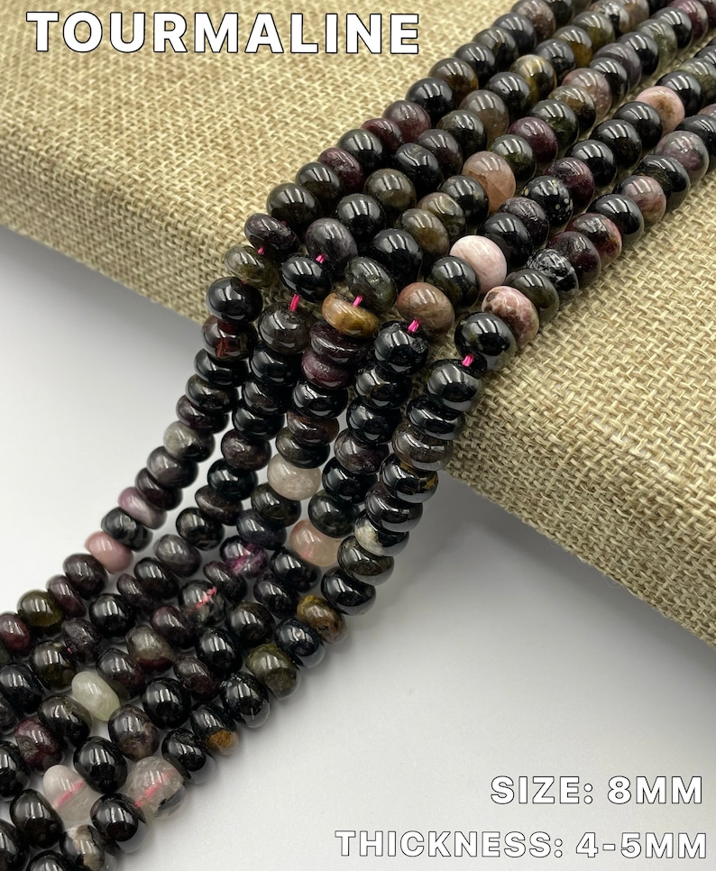 May include: A strand of black tourmaline beads with green and pink inclusions. The beads are 8mm in size and 4-5mm thick.  TOURMALINE is written at the top of the image. SIZE: 8MM and THICKNESS: 4-5MM are written at the bottom of the image.
