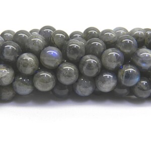 May include: A strand of round, gray labradorite beads. The beads have a slight iridescent sheen.