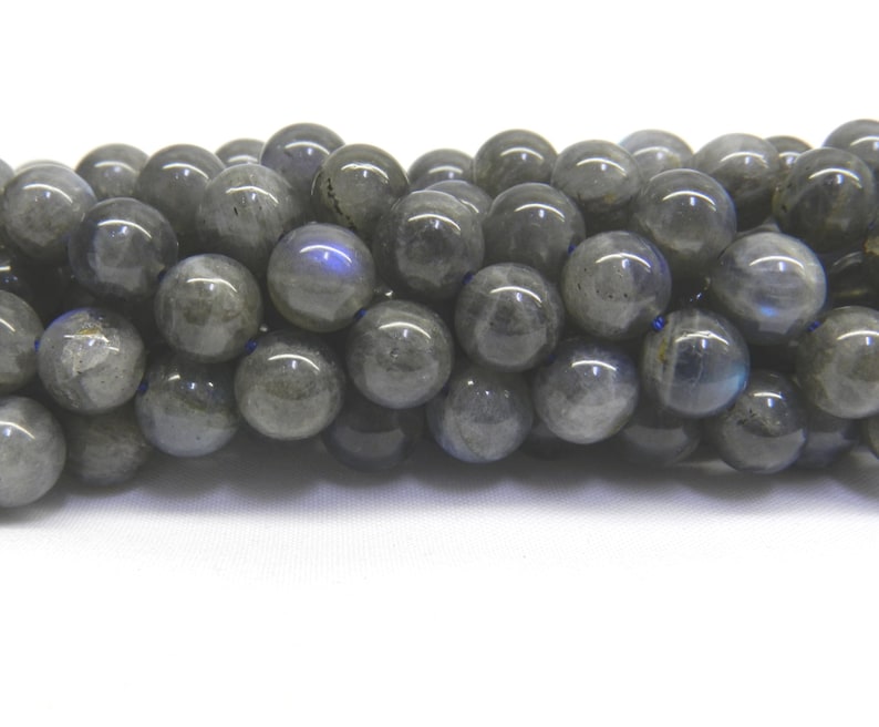 May include: A strand of round, gray labradorite beads. The beads have a slight iridescent sheen.