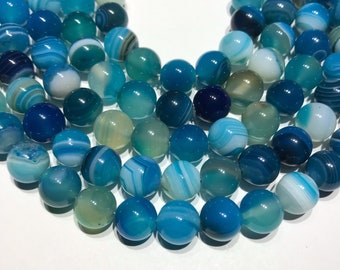 May include: A strand of blue agate beads with white and light blue banding. The beads are round and measure 10mm in diameter.