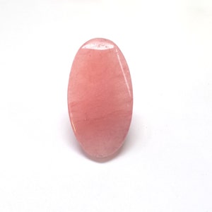 Könnte beinhalten: Ein glatter, ovaler Rosenquarz-Roller, ein Werkzeug für die Gesichtsmassage.