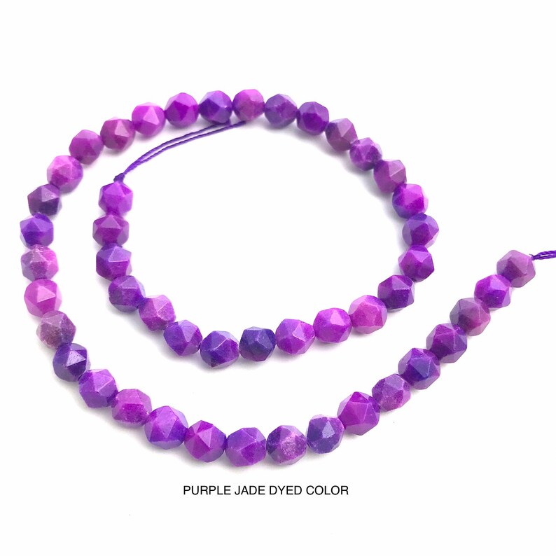 May include: Strands of faceted, purple jade beads. The beads are strung on a purple cord and are a deep, rich purple color. The text "PURPLE JADE DYED COLOR" is at the bottom of the image.