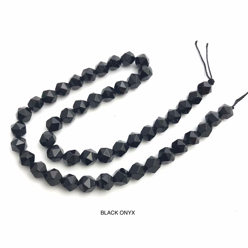 May include: Strands of faceted black onyx beads. The beads are strung on black thread and are displayed against a white background. The text "BLACK ONYX" is at the bottom of the image.
