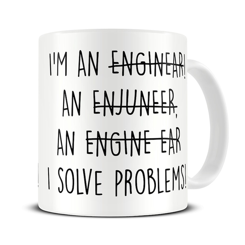 Op de afbeelding: Witte keramische mok met zwarte tekst die luidt: "Ik ben een ingenieur, een enjuneer, een engine-ear, ik los problemen op!"