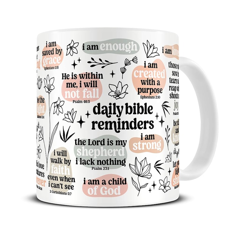 Peut inclure: Mug en c&eacute;ramique blanche avec l'inscription "daily bible reminders" et des citations inspirantes et des motifs floraux en noir, p&ecirc;che et gris. La tasse comprend des phrases comme "I am enough" et "I am strong".