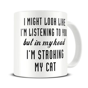 May include: White ceramic coffee mug with black text that reads "I might look like I'm listening to you but in my head I'm stroking my cat."