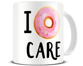 May include: White ceramic mug with a pink and white donut graphic and the text "I donut care".