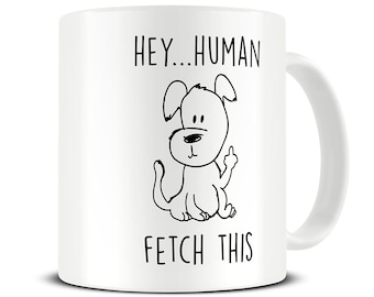 May include: White ceramic coffee mug with a black and white illustration of a dog giving the middle finger. The text "Hey... Human Fetch This" is printed on the mug.