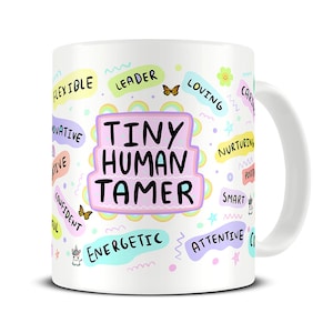May include: White ceramic mug with a pink and purple design. The mug features the text "Tiny Human Tamer" surrounded by words like "leader", "loving", "energetic", and "attentive".