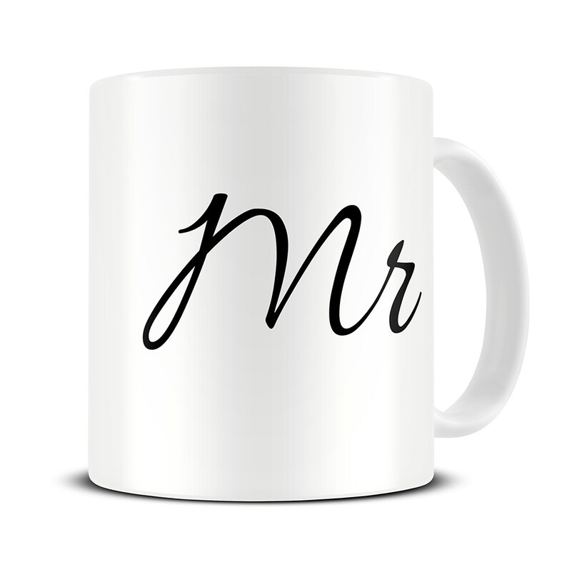 以下が含まれることがあります： 黒い筆記体で「Mr.」と書かれた白いセラミック製のマグカップです。
