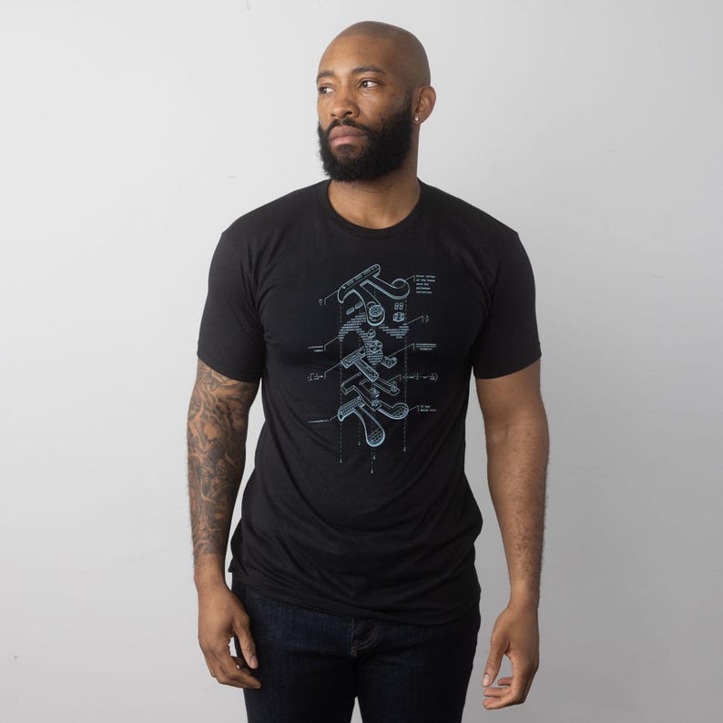 Może przedstawiać: Czarny t-shirt z jasnoniebieskim wzorem diagramu, prawdopodobnie przedstawiającym kij golfowy. Koszulka ma okrągły dekolt i jest wykonana z miękkiego materiału. Diagram jest ilustracją techniczną.