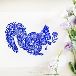May include: Blue and white illustration of a squirrel with a floral design. The squirrel is holding a branch with a flower on it. The image is signed "Suzanne Kruisdijk" and includes the copyright "© 2019 SUZANNE KRUISDIJK".
