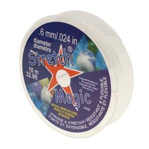 Könnte beinhalten: Weiße Spule mit Stretch Magic Perlen- und Schmuckschnur. Die Spule ist mit dem Text "Stretch Magic" und "6 mm/.024 in Durchmesser" beschriftet. Die Spule gibt auch an, dass die Schnur stark und dehnbar, widerstandsfähig und flexibel ist. Die Spule enthält 10 Meter (32,9 Fuß) Schnur.