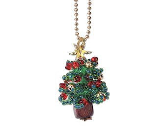 May include: A gold chain necklace with a beaded Christmas tree pendant. The tree is decorated with red and green beads, and a gold star on top.